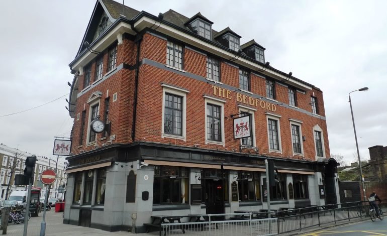 The Bedford in Balham, a historic red-brick building with a clock on its facade, known for hosting live music and theatrical performances from Wandsworth Art Fringe.