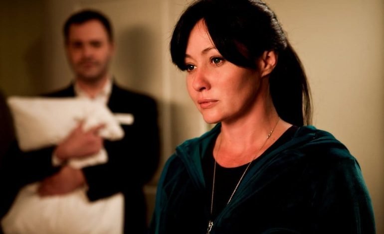 Shannen Doherty in a reflective moment, wearing a green hoodie