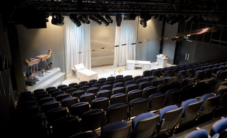 Studio 3 at Riverside Studios, Hammersmith, with a view of the stage with furniture, stage lighting and white backdrop