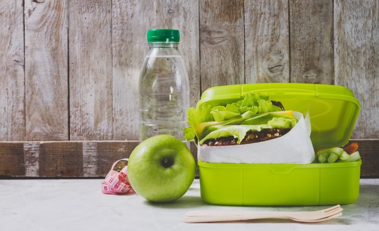 A colorful school lunch box filled with a healthy assortment of foods, including a sandwich and apple. Wandsworth Council is moving to address food insecurity in London schools