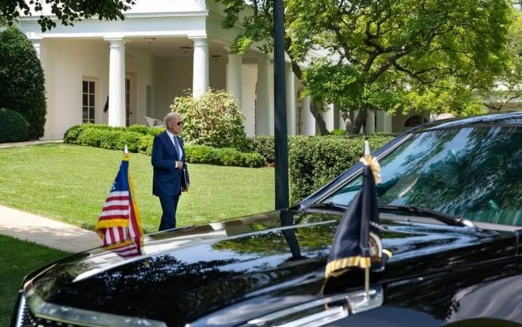 Press conference image of President Joe Biden walking outside the White House near a black presidential car