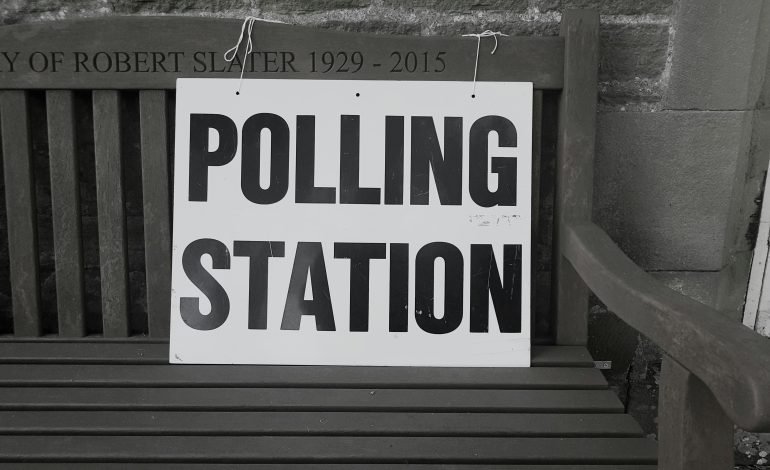 Voters' guide polling station sign on a bench