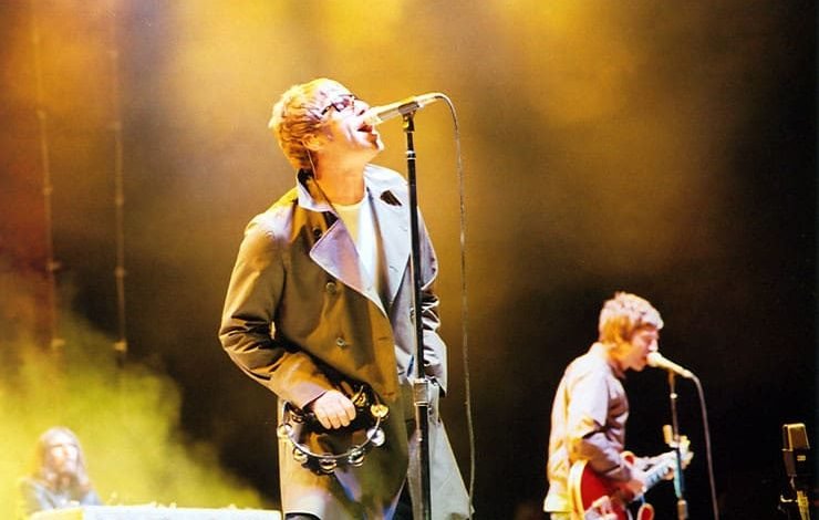 Liam and Noel Gallagher performing on stage during an iconic Oasis concert, sparking renewed hopes for a possible Oasis reunion.