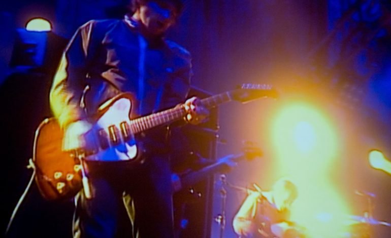 Live performance of Oasis guitarist under stage lighting, capturing the energy and atmosphere of the concert. This is to symbolise the Oasis Reunion Tour 2025.