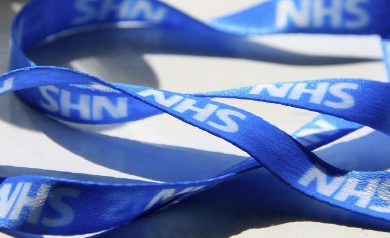 Close-up image of a blue NHS lanyard with the letters "NHS" clearly visible in white text on a light background