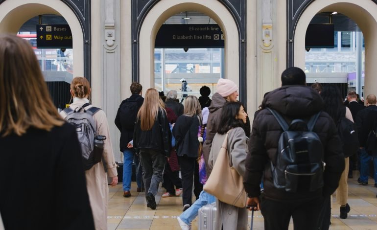 Passengers at train station during the UK's train strike dates, navigating travel disruptions with luggage in tow.