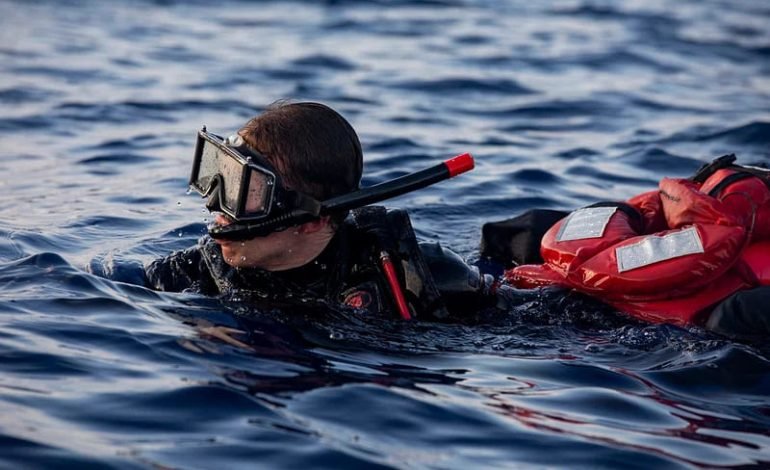 Rescue diver in the sea during search operation for missing individuals after British flagged yacht sinks off the coast of Sicily.