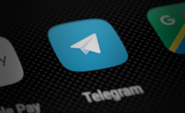 Telegram's criminal activities represented by the app icon on a smartphone screen, highlighting the platform's moderation controversies.