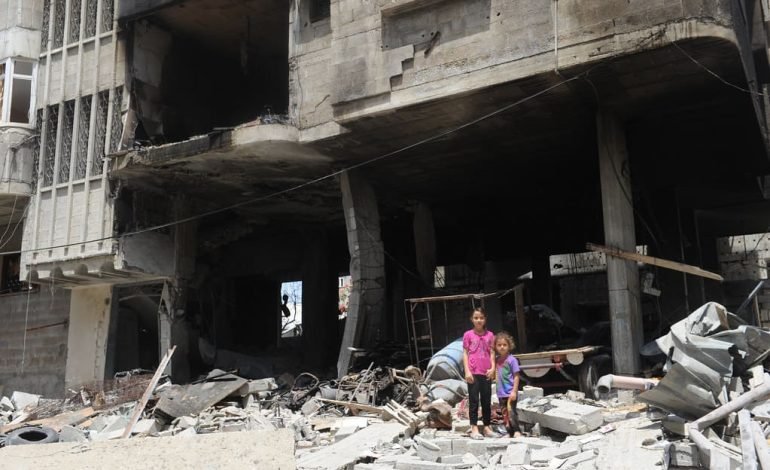 Aftermath of Israel attack on residential area, children standing amidst rubble in Beirut.