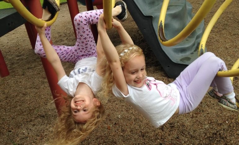 Children playing on the new Kensington playground equipment at Longlands Estate, enjoying the renovated community space.