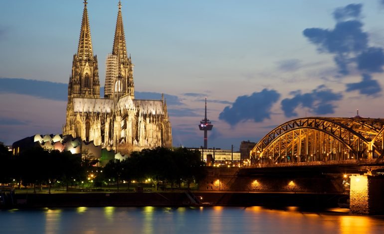 Cologne's iconic skyline with the Cathedral and Hohenzollern Bridge at dusk, highlighting the setting of Fel!x, the festival of Early Music held annually at the Philharmonie