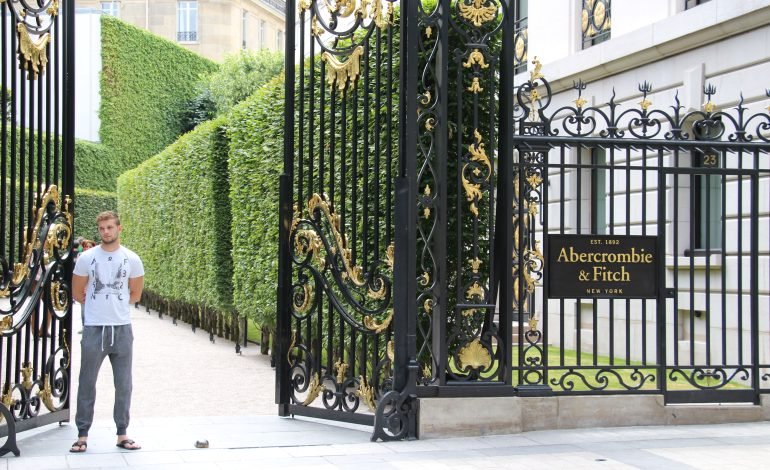 Entrance gate to Abercrombie & Fitch location in Paris, featuring a guard in Abercrombie clothing, highlighting the brand’s luxurious style.