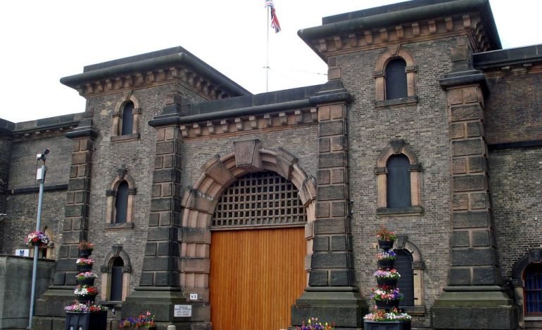 Entrance of a UK prison, highlighting the current early release of UK prisoner capacity crisis.