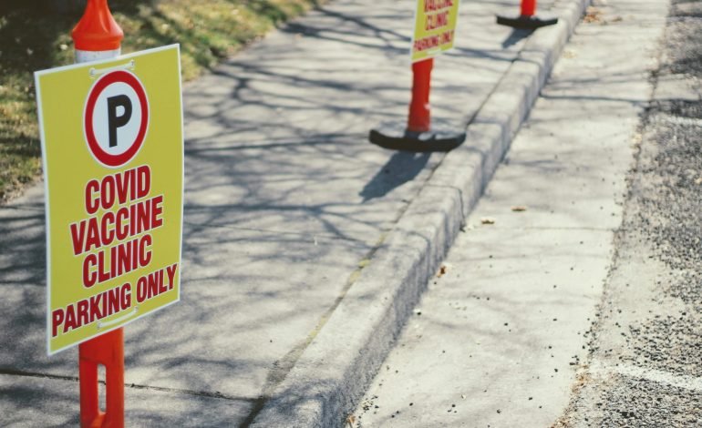 Sign for Covid Vaccine Clinic Parking Only, highlighting new Covid measures and vaccination efforts.
