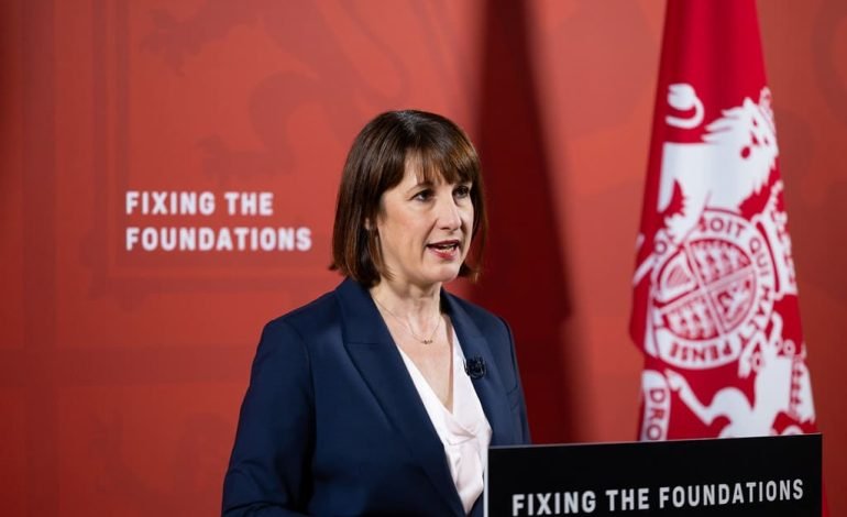 Chancellor Rachel Reeves presenting the Latest UK Budget under the theme 'Fixing the Foundations' with a red backdrop and a UK flag.