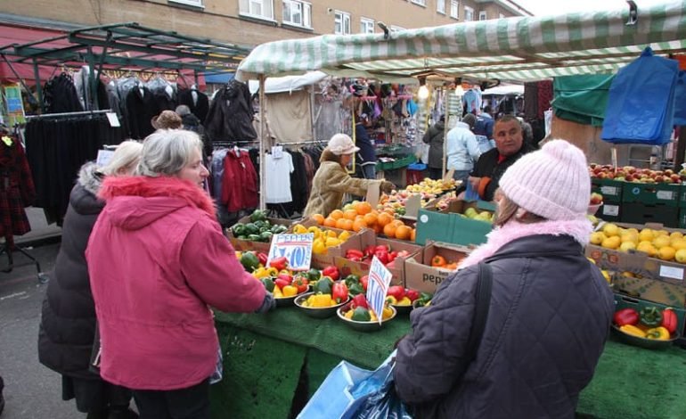 Market traders and shoppers at East Street Market in Walworth, London, where a recent stabbing incident took place, capturing the community atmosphere.