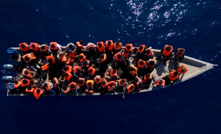 UK border security to combat people smuggling Migrants in a small boat with life jackets, representing the challenges of illegal crossings.