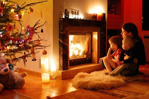 A cosy living room with a crackling fire, a classic Christmas curled up together.