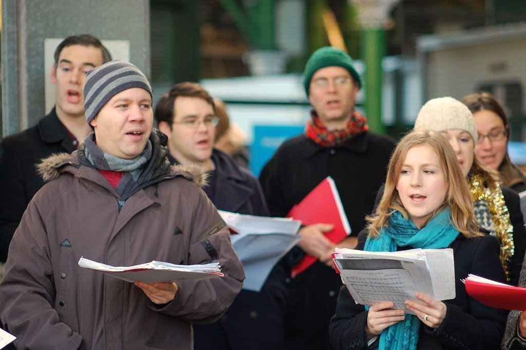 Carol singers spreading joy in a UK neighbourhood during Christmas.