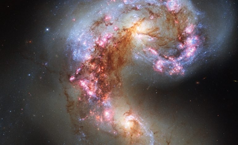 Galaxies crashing together in a cosmic collision showcasing early universe star formation.