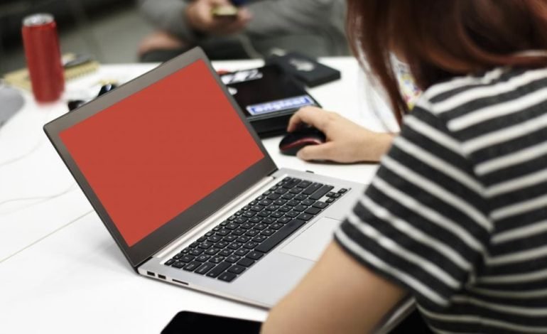 UK youth searching for job opportunities on a laptop as unemployment concerns rise.