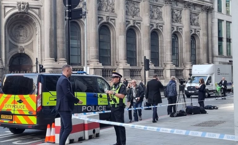 City of London Police officer speaking to a man outside a historic building, symbolising a heartfelt reunion in the Square Mile.