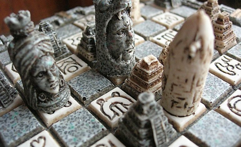 One of the most iconic matches in chess history, the Spassky vs Fischer showdown, represented on a Mayan themed chess set with intricately carved pieces.
