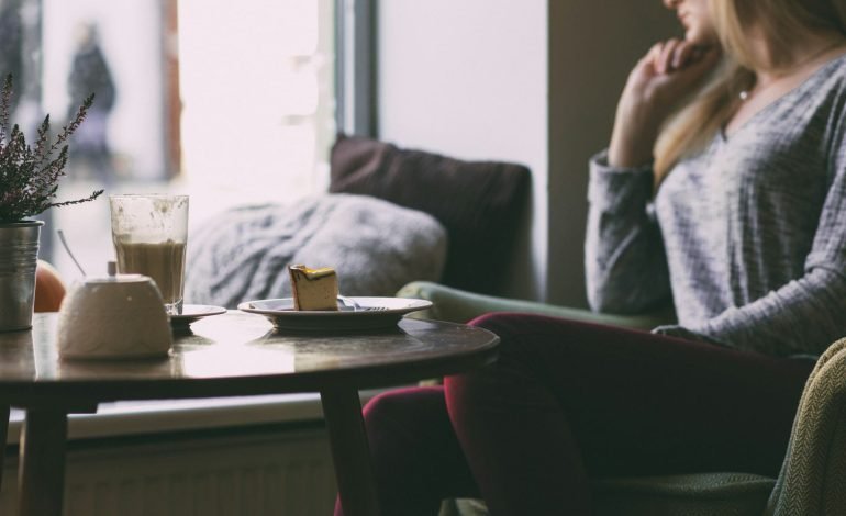 woman alone in home looking out window for article on funding