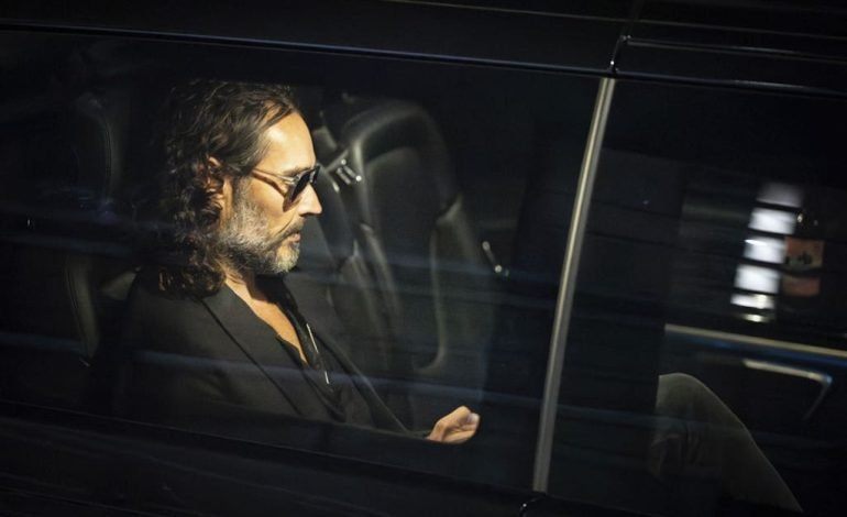 Russell Brand photographed through a car window following charges of rape and sexual assault in the UK