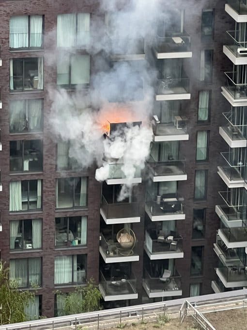 Smoke and flames coming from a flat during the Aldgate high rise fire in east London