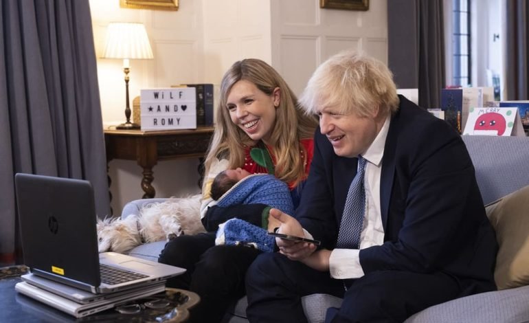Boris and Carrie Johnson welcome daughter Poppy while sitting on a sofa with their newborn and children’s names in the background