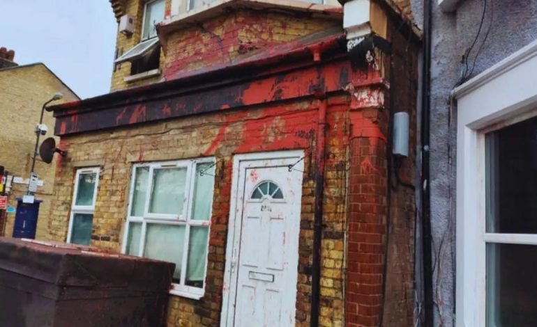 Red paint vandalism in Walthamstow with 'brothel' graffiti marking front of a residential property