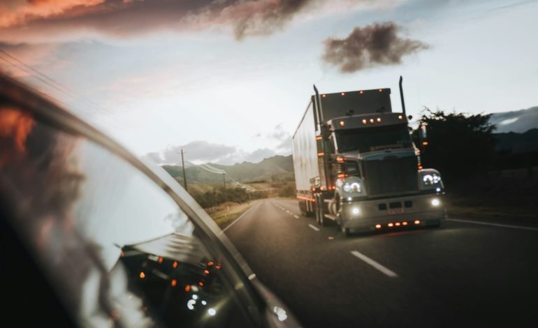american lorry on the highway photo taken from rear side window of a car