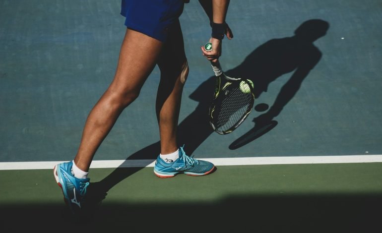 woman holding tennis ball & racket on tennis court like the carlisle park courts