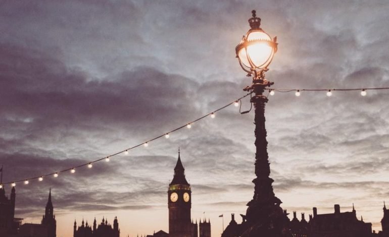 Cloudy London skyline with streetlight and Big Ben under early evening sky during UK summer weather