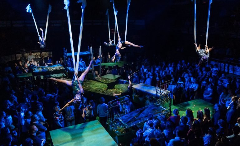 Immersive aerial performance of A Midsummer Night's Dream at Bridge Theatre with audience standing around stage platforms