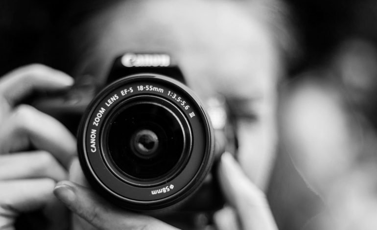 photographer taking a photo with a camera and a lens