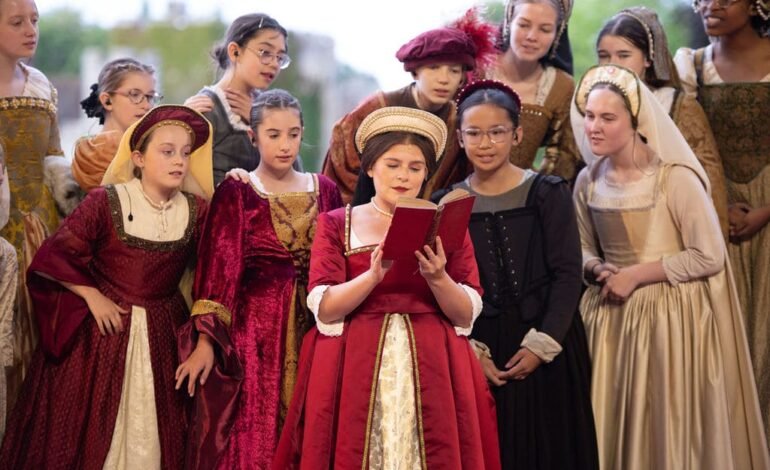 Anne Boleyn The Musical review — Emily Lane as Anne Boleyn reading with ensemble at Hever Castle outdoor theatre