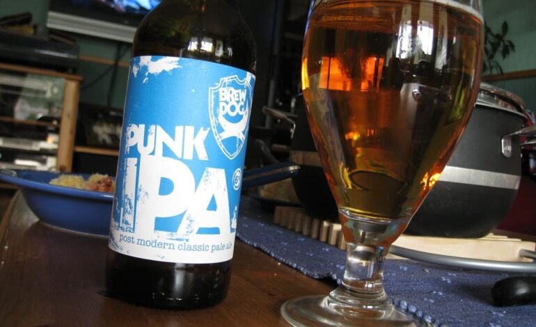 BrewDog Punk IPA bottle and poured glass of beer on a table, once considered the flagship of UK craft beer pubs.