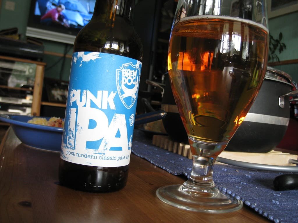 BrewDog Punk IPA bottle and poured glass of beer on a table, once considered the flagship of UK craft beer pubs.