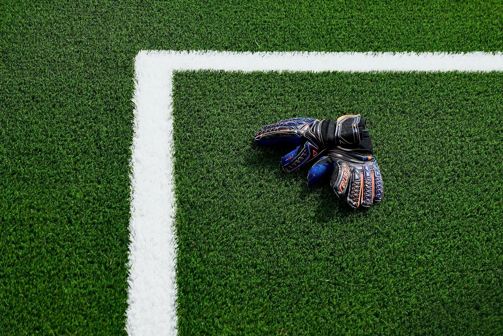 goalkeeper gloves lying on a pitch