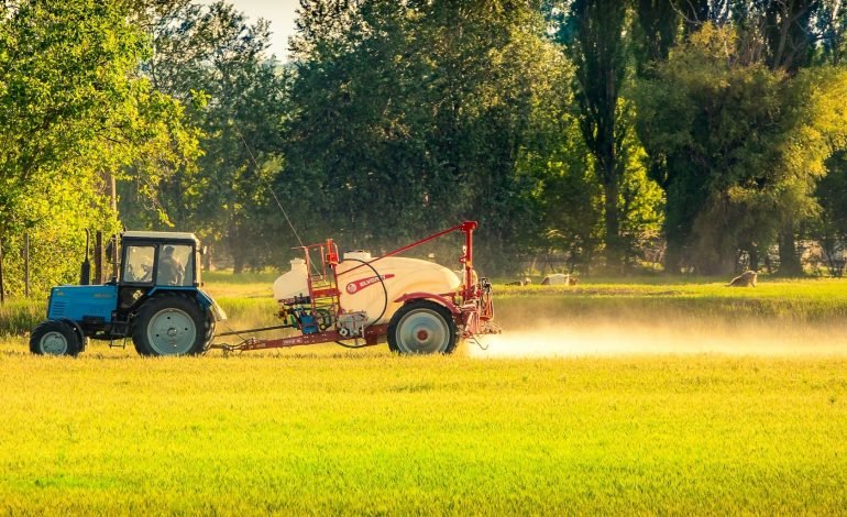 tractor on a field possibly spraying pesticide