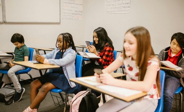 Children using smartphones in a classroom as campaigners call for a smartphone ban in schools