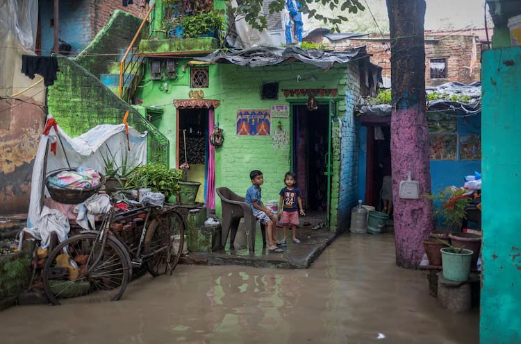 Investing in climate resilience in India as children stand by monsoon flooding outside homes