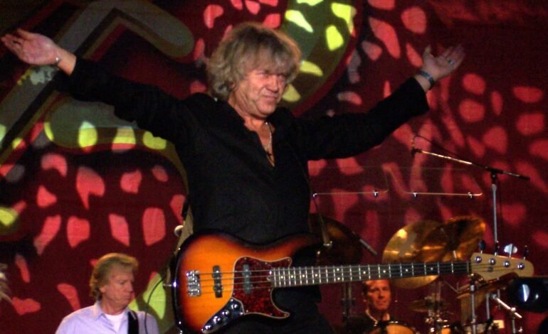 John Lodge performing live on stage with his bass guitar, The Moody Blues, British rock legend.