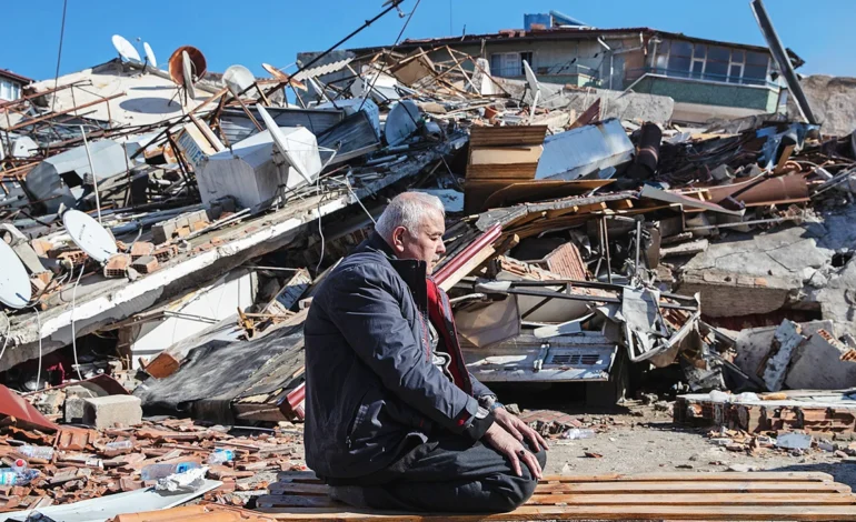 Man sitting amid rubble of collapsed buildings after the Balikesir earthquake in western Turkey.