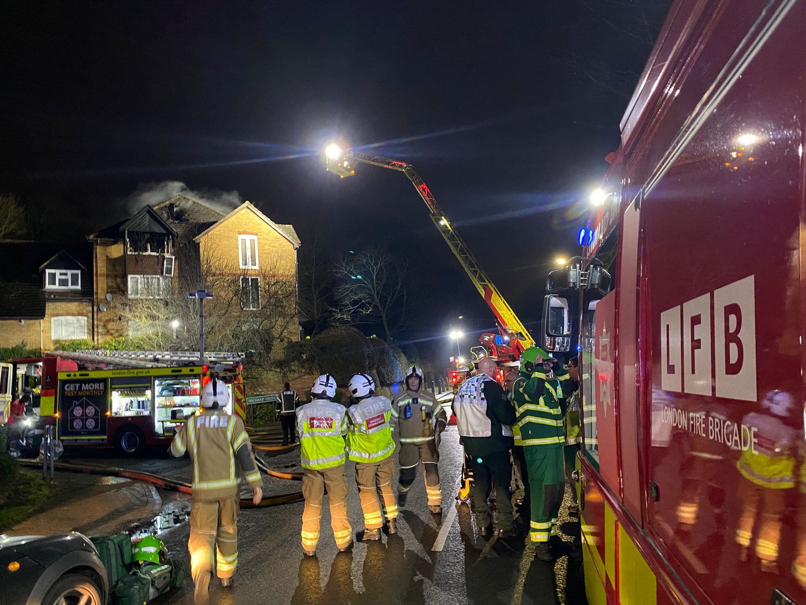 Penge fire scene at night with London Fire Brigade crews and aerial ladder tackling blaze at residential building