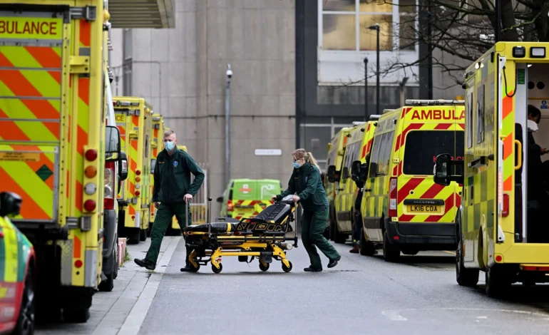 NHS job cuts 18,000 staff across England as paramedics work outside hospitals surrounded by ambulances