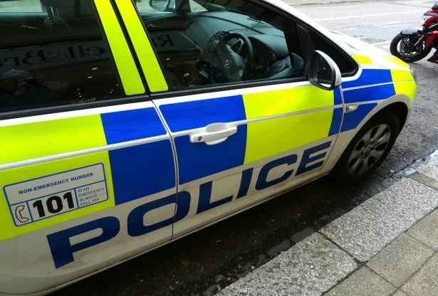 Police car parked at the roadside following a kidnap and cryptocurrency robbery in Oxford