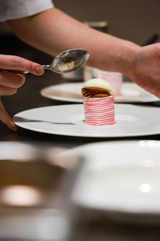 A dessert course being finished in the kitchen at 74 Charlotte Street, where restraint and balance guide the final plates.